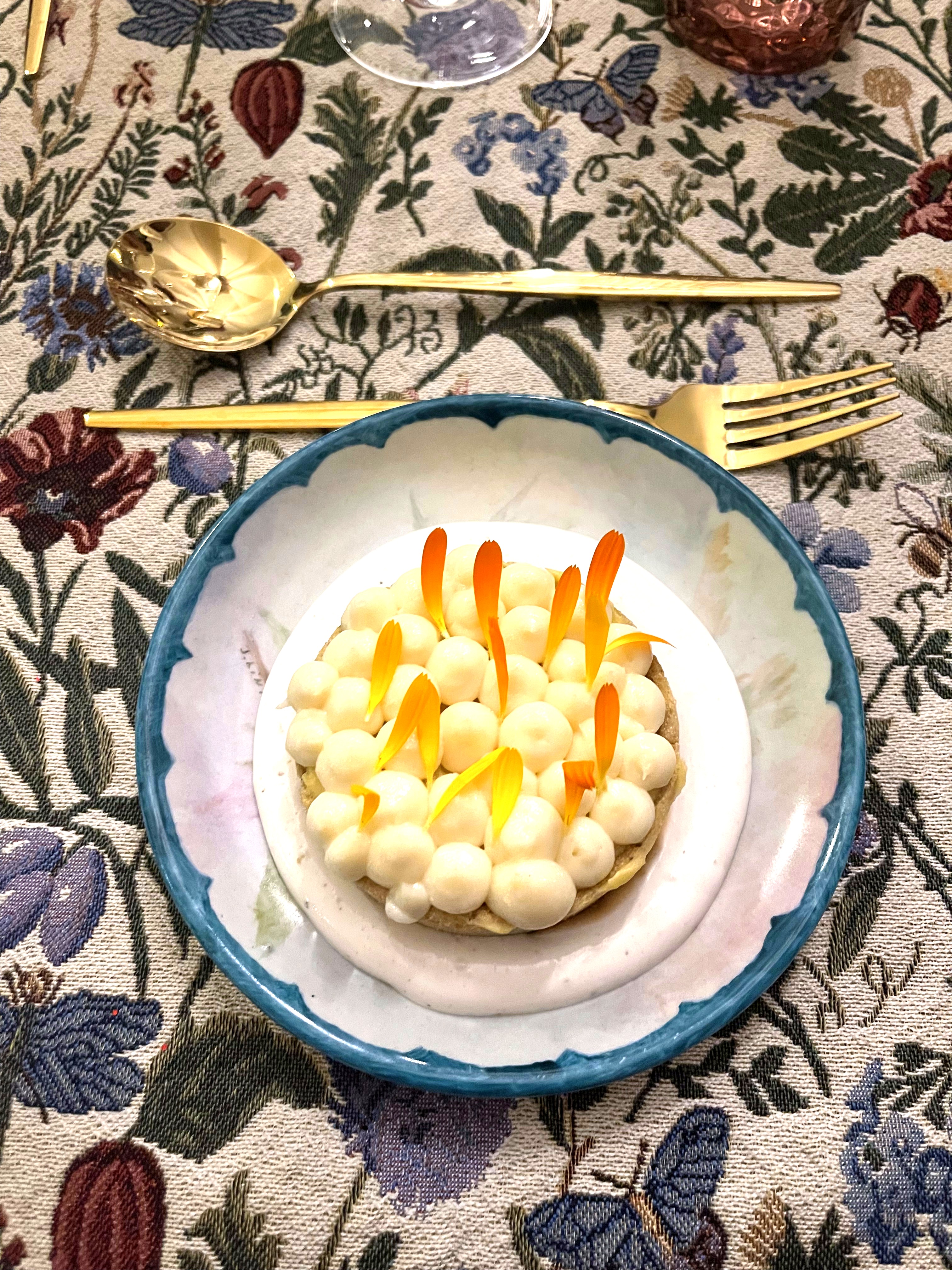 Plated dessert with white pearls and orange petals