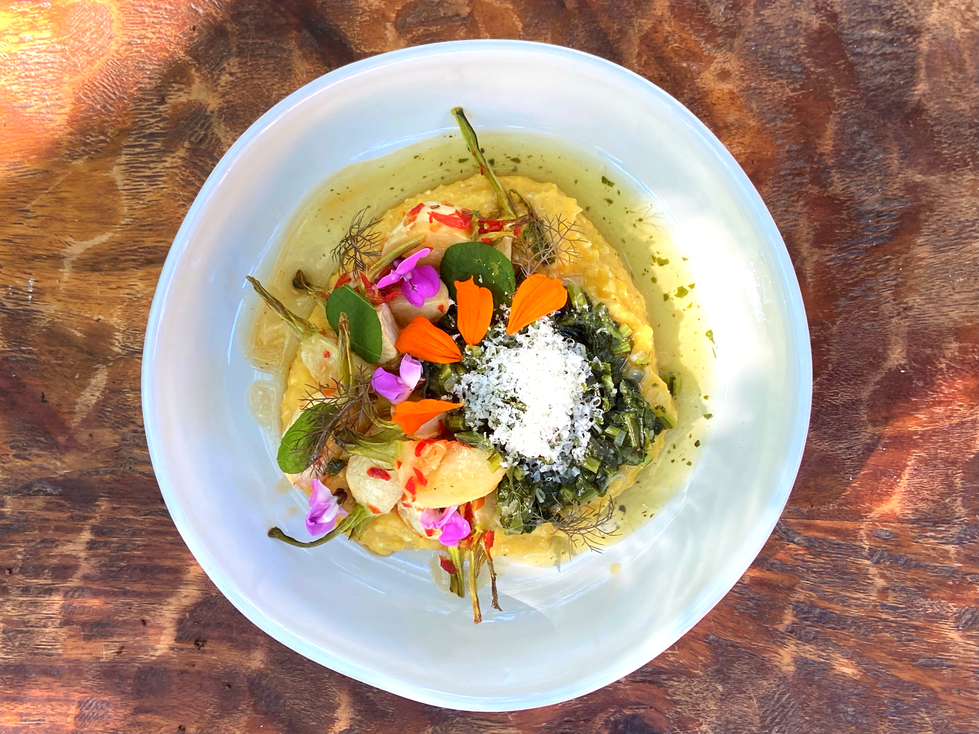 Overhead shot of flower-topped dish on wood table