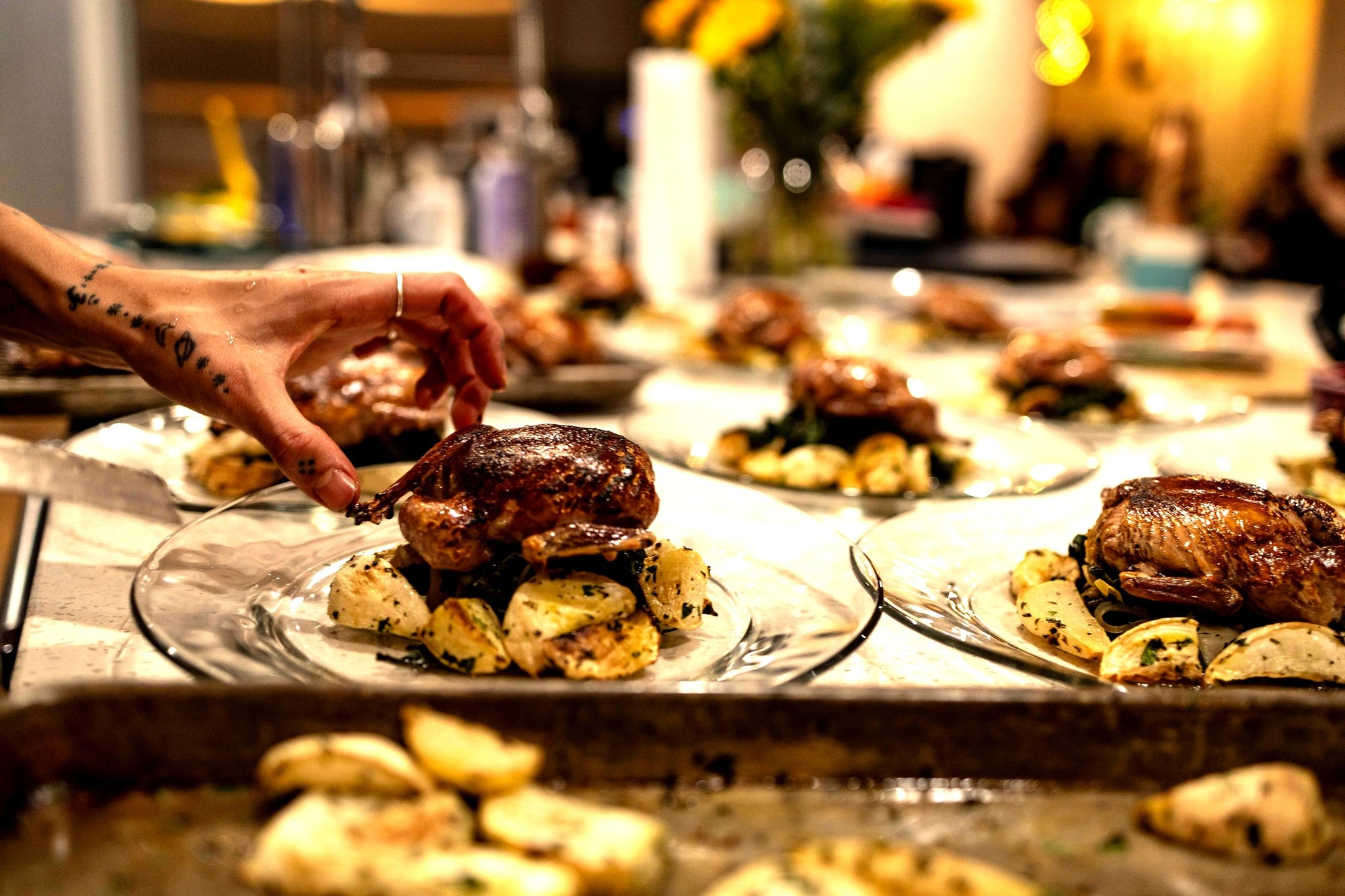 Chef placing roasted bird on a row of plates