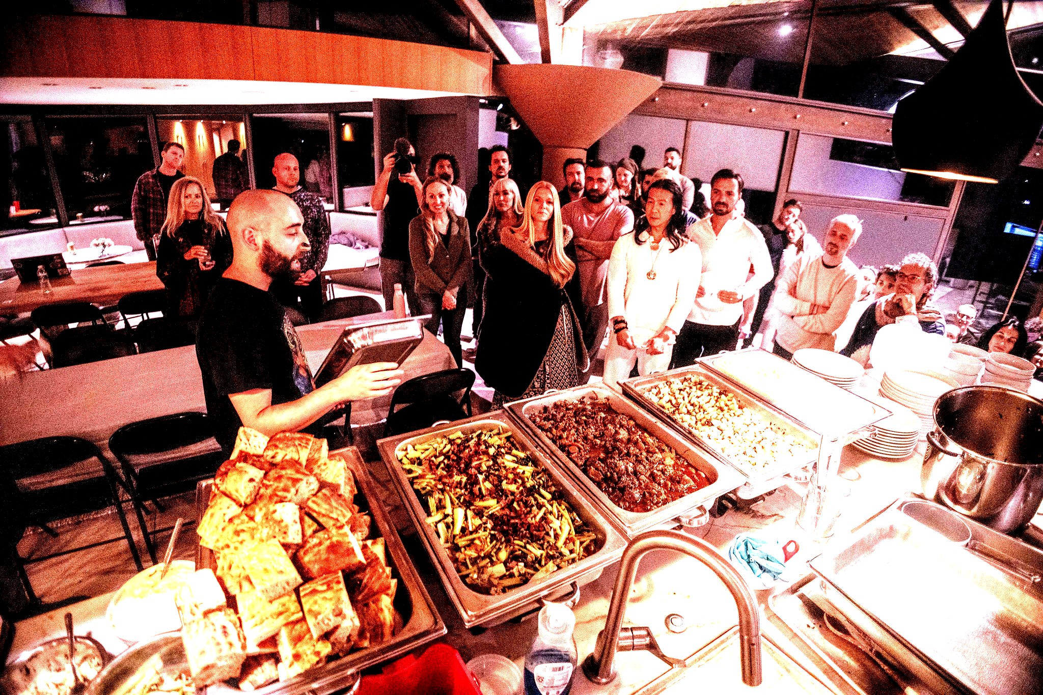 Chef Zen addressing a crowd at a large retreat buffet spread